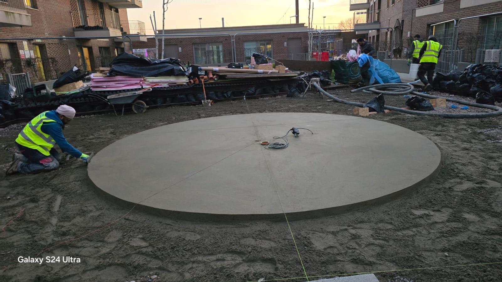 LCM Ltd operative finishing the edge of a circular concrete pour in a residential courtyard.